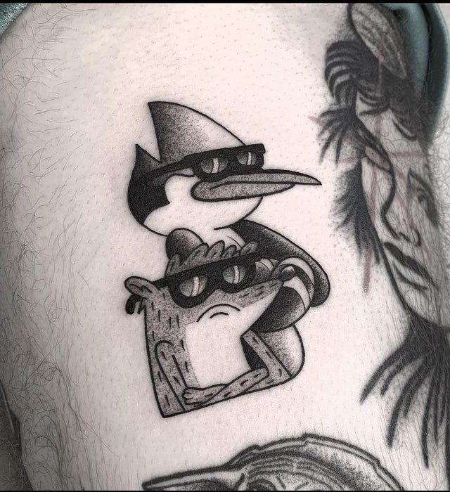 a close up of a person's stomach with tattoos on it and an image of a bird wearing a hat