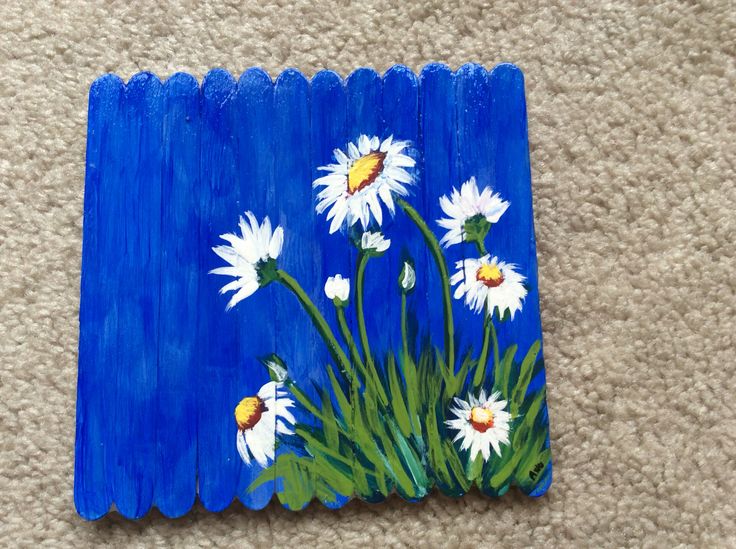 a painting of white daisies on blue painted wood planks with grass and flowers