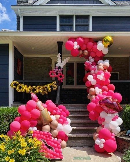 the balloon arch is decorated with balloons and confetti for an entrance to a house