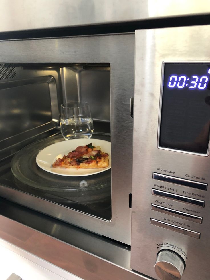 a plate with pizza on it is in an oven and the clock shows 9 30