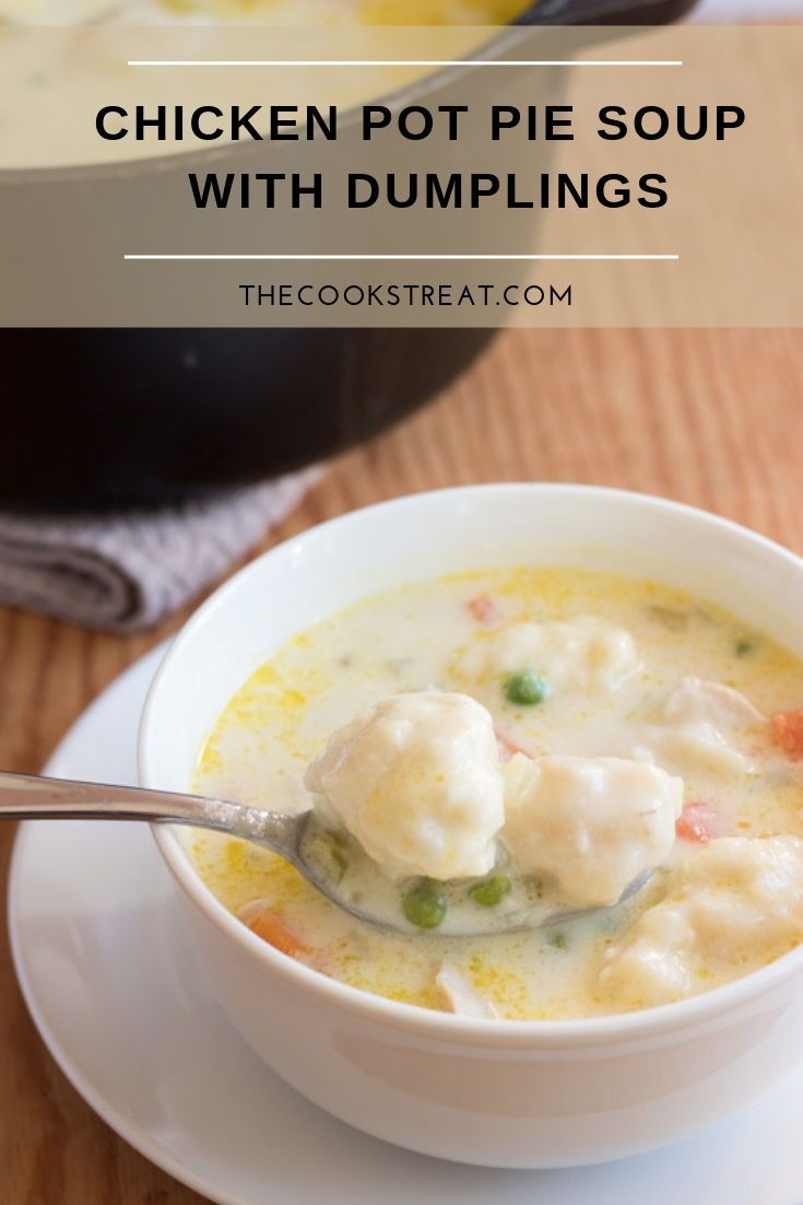 chicken pot pie soup with dumplings in a white bowl on a wooden table top