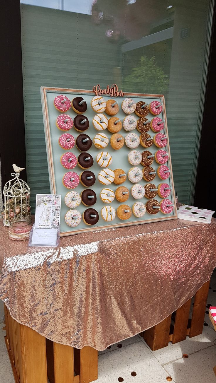 a table topped with lots of donuts next to a window