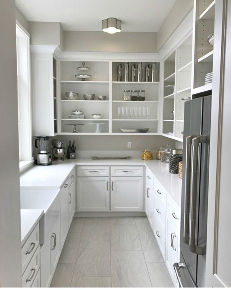 a kitchen with white cabinets and counter tops