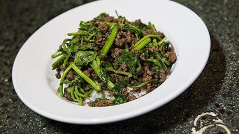 a white plate topped with meat and broccoli on top of a granite counter