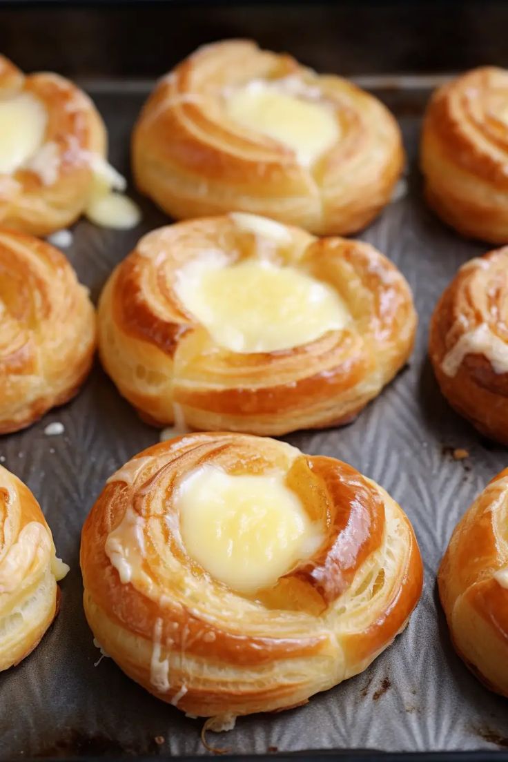 many pastry items are on a baking sheet and ready to be baked in the oven