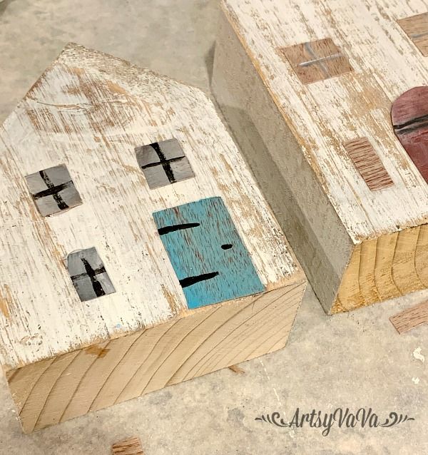 two wooden houses with crosses painted on them sitting on the floor next to each other