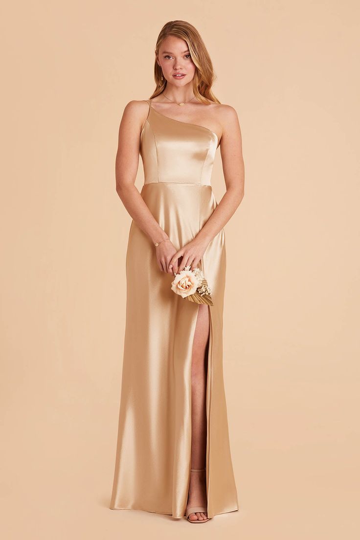 a bridesmaid in a champagne colored gown holding her bouquet and posing for the camera