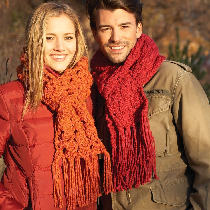 a man and woman standing next to each other wearing scarves, scarfs and jackets