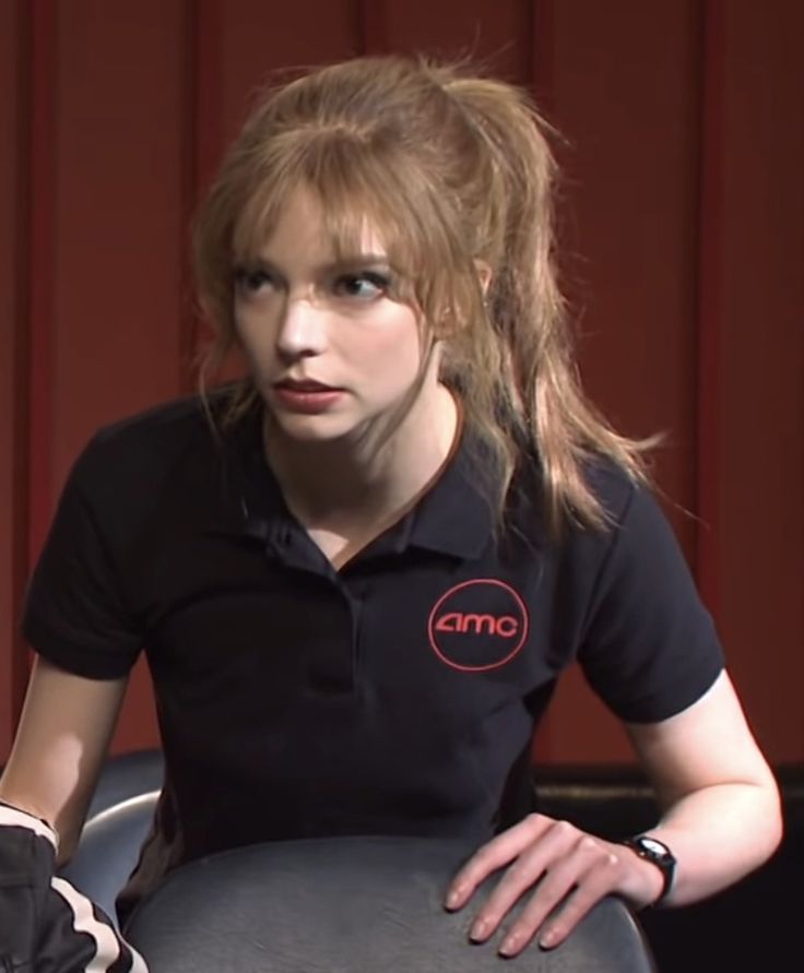 a woman sitting in a chair wearing a black shirt