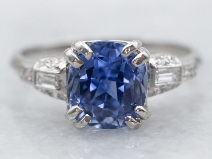 a blue sapphire and diamond ring on a white surface