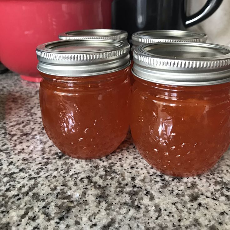 two jars filled with liquid sitting on top of a counter