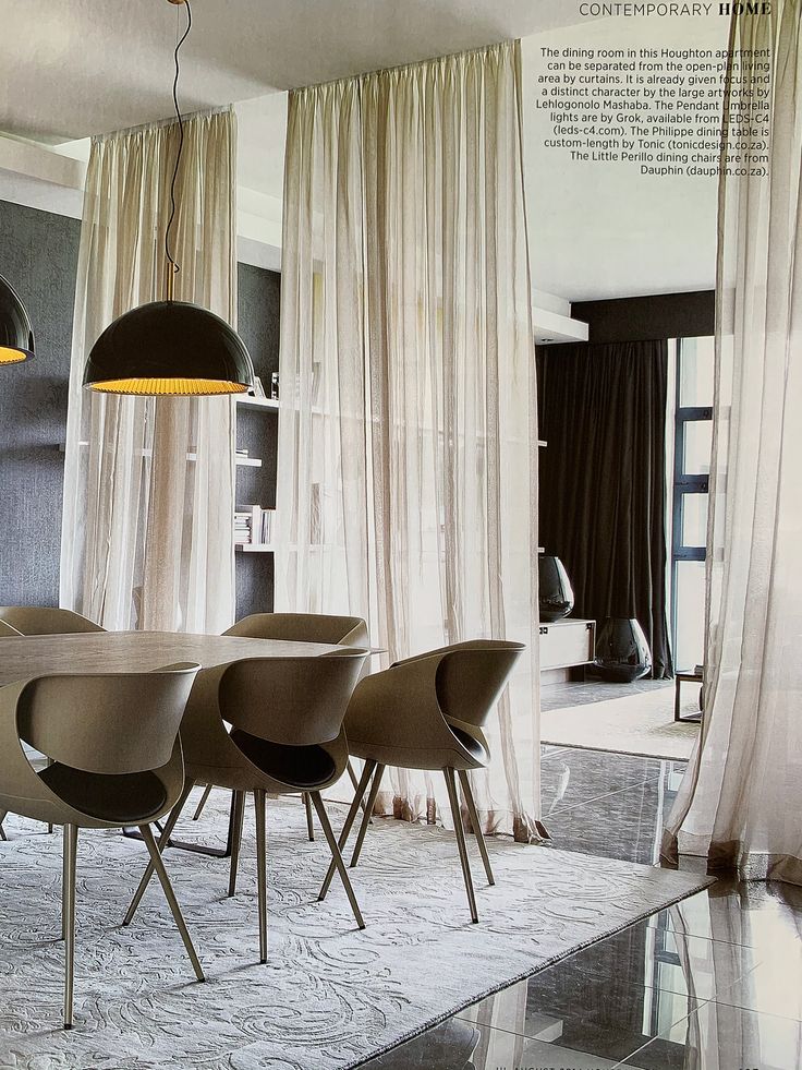 a dining room table with four chairs and a lamp hanging from the ceiling over it