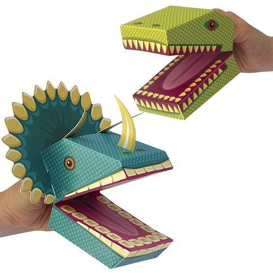 two paper dinosaurs are being held in the air