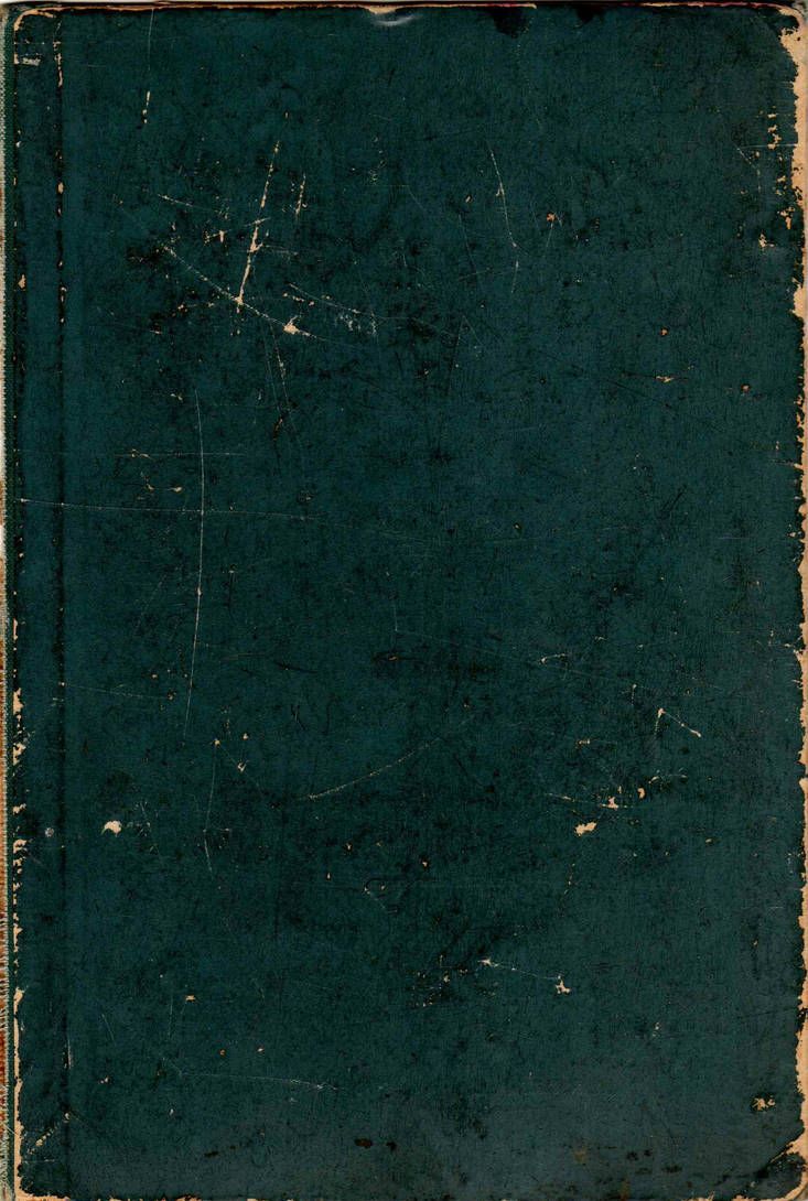 an old black book with white writing on the front and back cover is sitting open