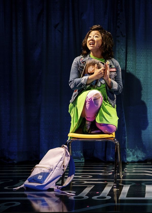 a woman sitting on a chair holding a baby in her arms and looking up at the sky