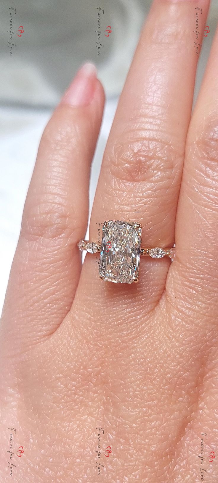 a woman's hand with a diamond ring on top of her finger and an engagement band