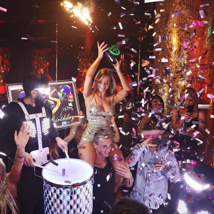 a group of people dancing and confettiing at a party