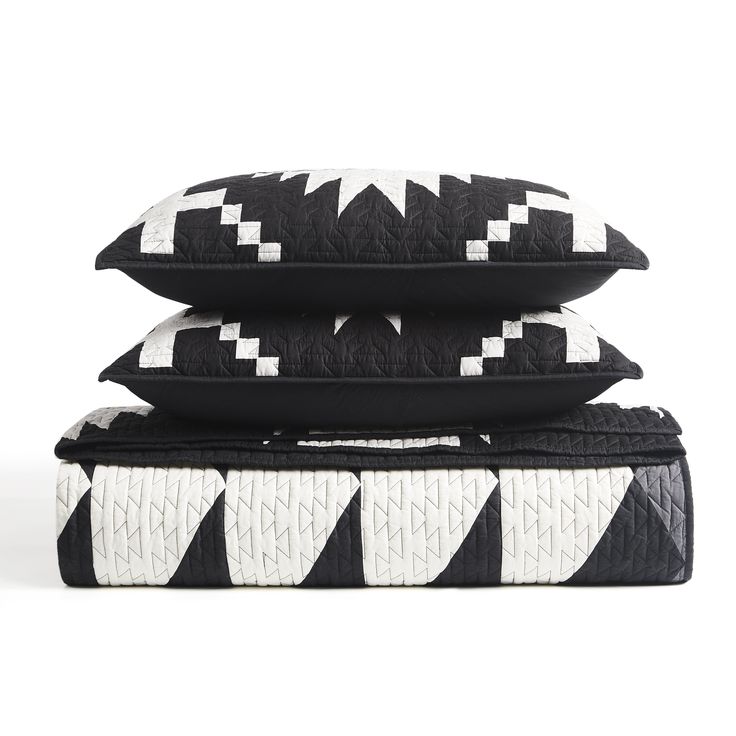 three black and white pillows stacked on top of each other