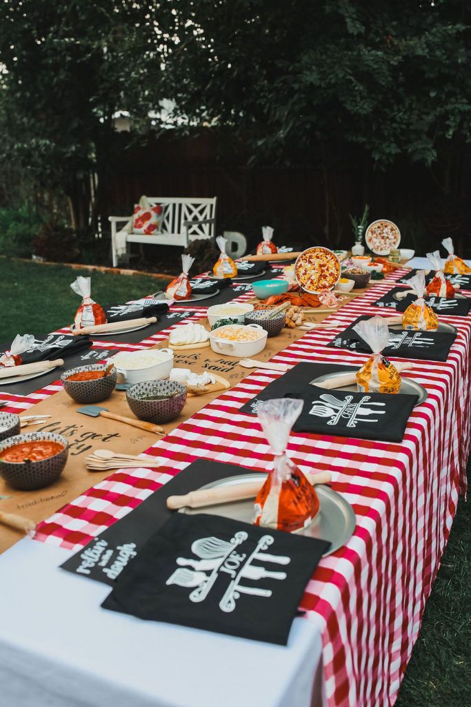 a long table covered in red and white checkered cloths with food on it