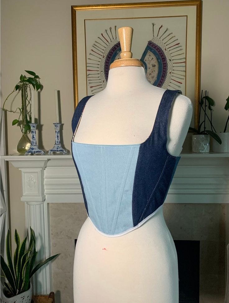 Over-bust corset with flexible boning and white lacing in back.  Made of a mismatch of four shades of denim. White mannequin's measurements - Waist: 27" Bust: 37" Blue mannequin's measurements - Waist: 30.5" Bust: 39.5" Generally here are the sizes: Small fits a US 4-8 (as seen on white mannequin) Medium fits a US size 6-12 Large fits a US 12-16 (as seen on blue mannequin) Sizing is pretty flexible because of lace-up closure. Message me if you have questions! Please send me your bust and waist measurements when ordering so i can make sure it will fit perfectly! Spring Denim Fitted Corset, Fitted Denim Blue Summer Corset, Fitted Denim Blue Cotton Top, Fitted Denim Blue Corset, Fitted Denim Blue Corset For Summer, Summer Denim Corset With Corset Back, Fitted Blue Spring Corset, Blue Fitted Corset For Spring, Blue Fitted Corset With Corset Back