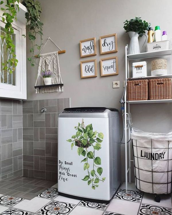 a laundry room with plants on the wall and pictures above the washer dryer