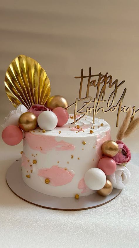 a birthday cake decorated with pink and gold decorations