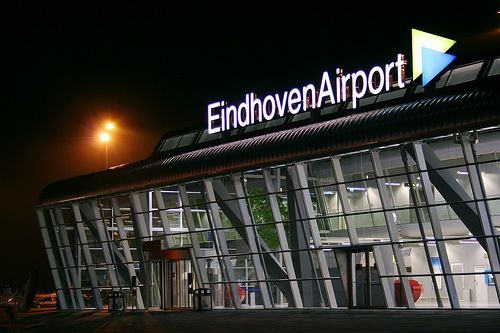 an airport terminal at night with the lights on and windows lit up for passengers to board