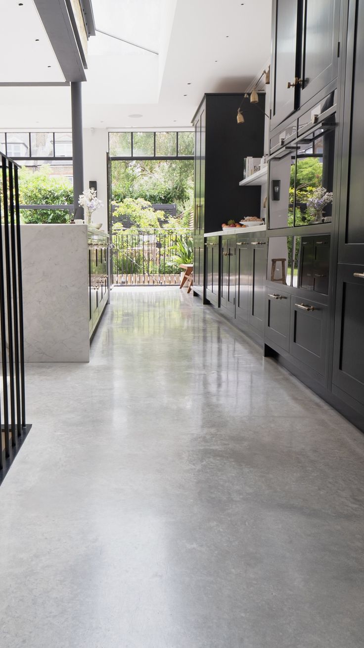 an empty kitchen with stainless steel appliances and black cabinets in the back drop off area