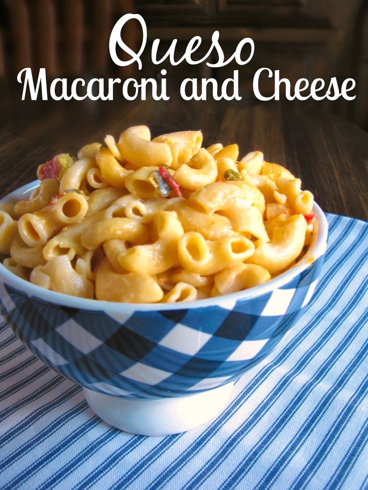 a bowl filled with macaroni and cheese on top of a blue checkered table cloth