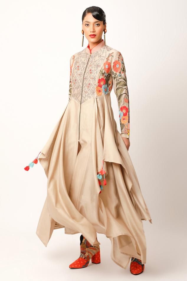 Beige kurta with multiple asymmetric draped panels, foliage pattern yoke, full sleeves, multi color patch, zari and thread embroidery. Paired with straight fit pant.
Components: 2
Pattern: Embroidered and Printed
Type Of Work: Applique, Thread and Zari Work
Neckline: Band Collar
Sleeve Type: Full Sleeves
Fabric: Silk Chanderi, Cotton Slub
Color: Beige
Other Details: 
Fringe drop tassels
Asymmetric hem
Multiple slit detail
Back inverted pleated detail
Length:
Kurta Back: 54 inches
Kurta Longest P Beige Kurta, Asymmetric Kurta, Pakistani Kurta, Indian Suit, Kurta Pant Set, Indian Kurta, Beige Silk, Straight Fit Pants, Silhouette Ideas