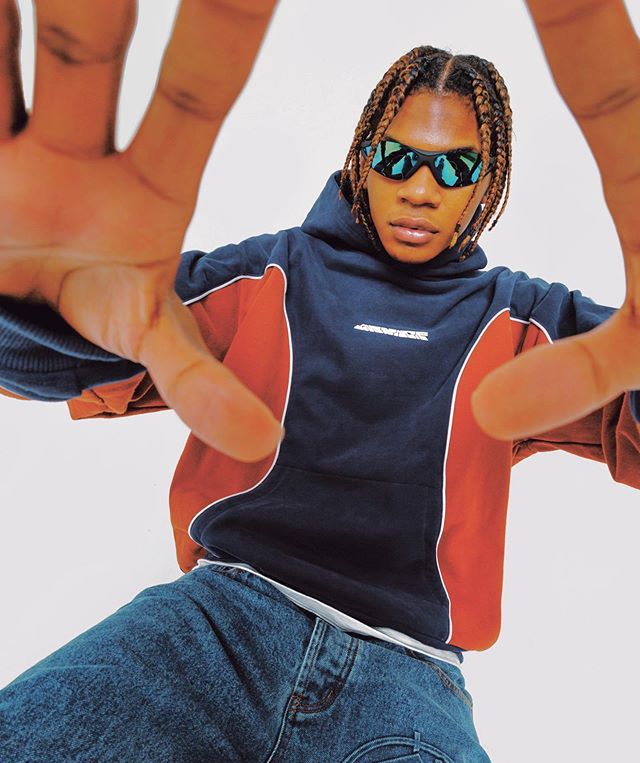 a woman with dreadlocks and sunglasses on her head is doing a hand sign