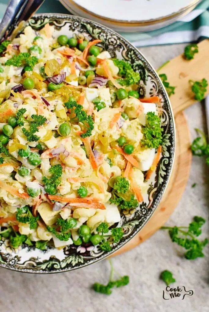 a bowl filled with salad next to a plate full of broccoli and carrots