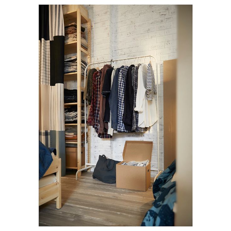 an open closet with clothes and boxes on the floor