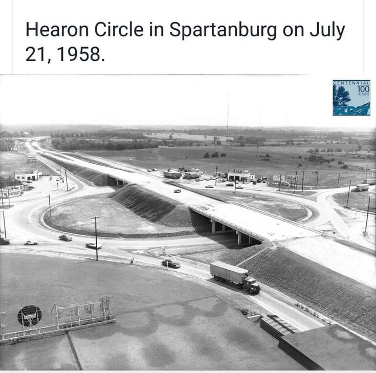 black and white photograph of an overpass with cars driving on the road in front of it