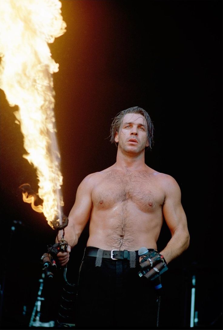 a shirtless man holding a fire extinguisher