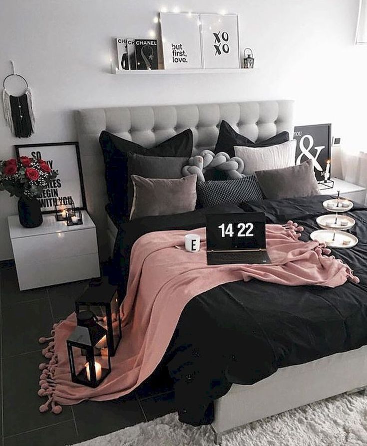 a black and white bedroom with candles on the nightstands, bedding and pillows