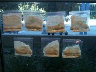 four bags of sand sitting on top of a window sill