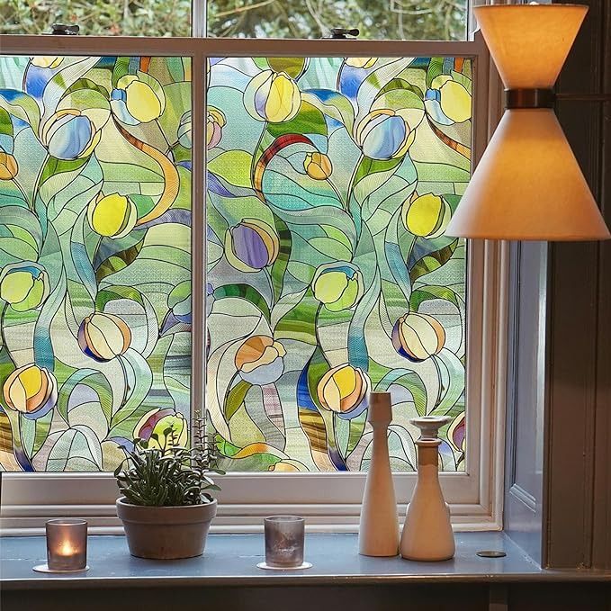 a stained glass window with two vases and a potted plant next to it