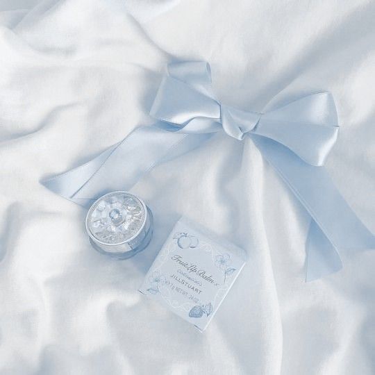 a white blanket with a blue bow and some cards on it