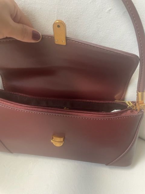 Get ready for fall with the must-have Audrey Bag! Its retro and classic design exudes chic style and will elevate any outfit. PU leather Imported Color: Burgundy Gold buckle and accents Approximate measurements: 11x4.7 in (Handle:10.62") Classic Brown Baguette Bag With Top Handle, Classic Brown Baguette Bag With Gold-tone Hardware, Classic Brown Baguette Bag, Retro Business Shoulder Bag With Detachable Strap, Classic Satchel Baguette Bag For Business, Classic Office Flap Bag With Hasp Closure, Classic Handheld Flap Bag With Detachable Handle, Elegant Brown Flap Bag With Metal Hardware, Classic Satchel Baguette Bag For Formal Occasions