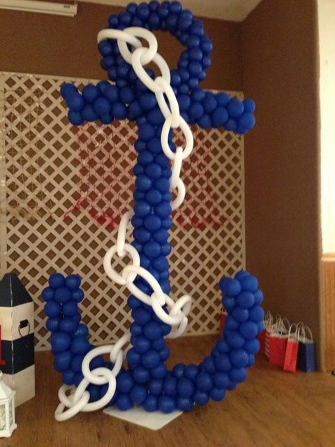 an anchor made out of balloons is on the table in front of a wall with other items