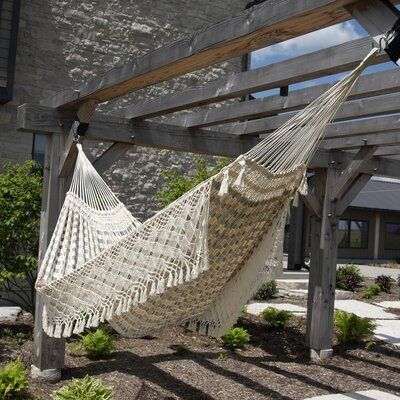 a white hammock hanging from a wooden structure