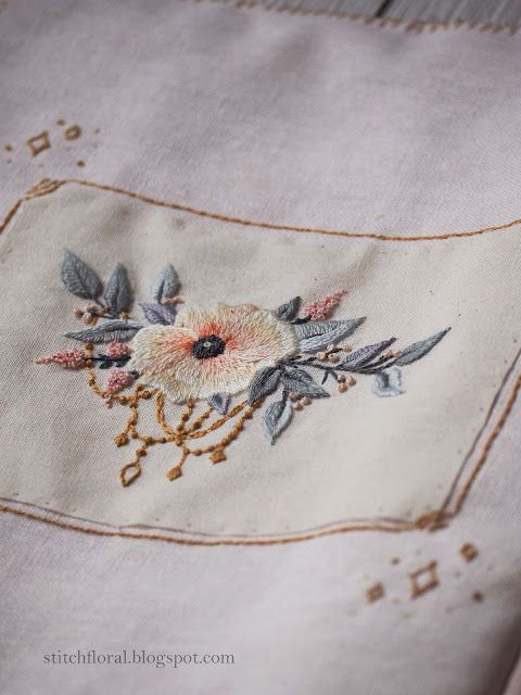 an embroidered piece of cloth with flowers on it