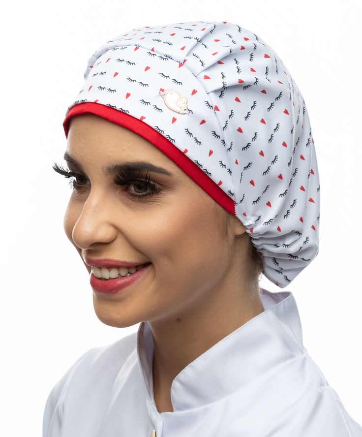 a woman wearing a white head wrap with red and black arrows on it, smiling