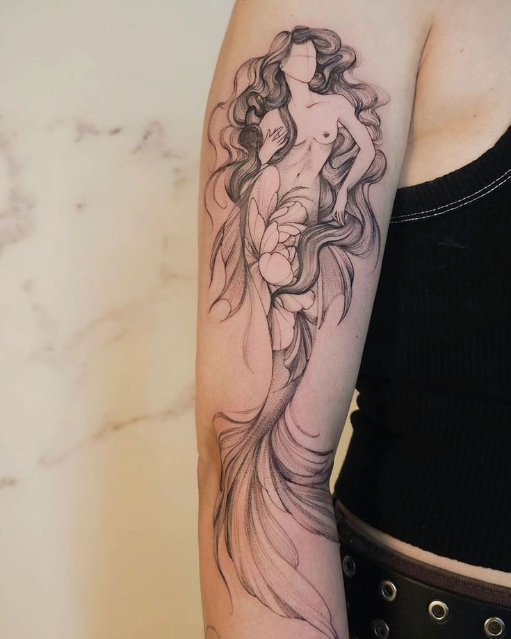 a woman's arm with a black and white tattoo design on her left arm