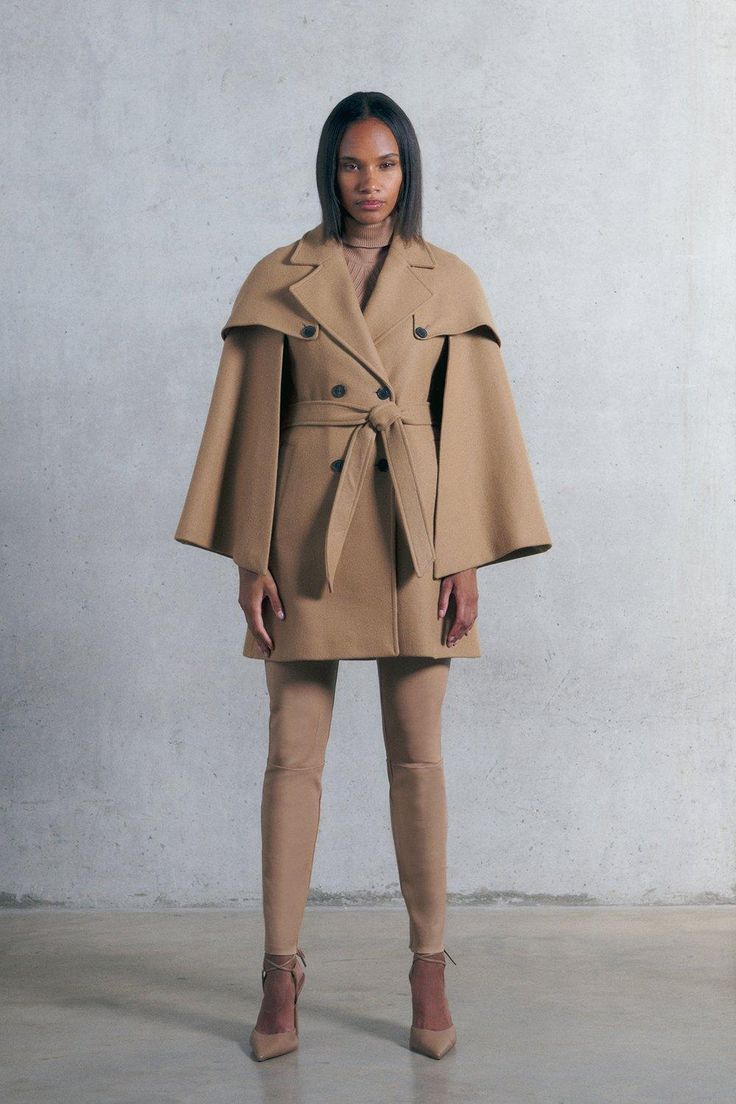 Beige Cape For Fall Workwear, Fall Wool Cape Coat For Work, Chic Fitted Wool Coat With Belted Cuffs, Chic Fall Cape Wool Coat, Beige Wool Cape Outerwear, Beige Cape For Winter Workwear, Chic Fitted Cape Outerwear, Fitted Cape For Workwear, Classic Cape Outerwear For Work