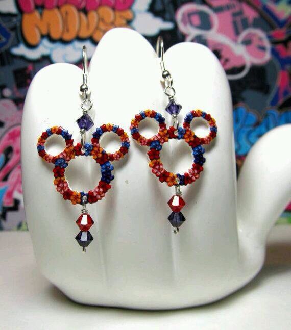 two pairs of earrings are displayed on a mannequin's head with graffiti in the background