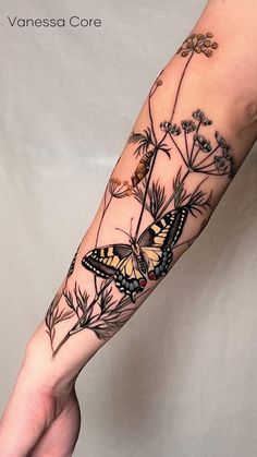 a woman's arm with a butterfly and flowers tattoo on the left side of her arm