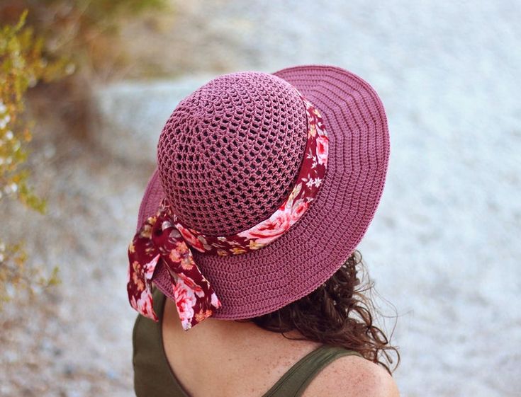 a woman wearing a purple hat with a flowered bow