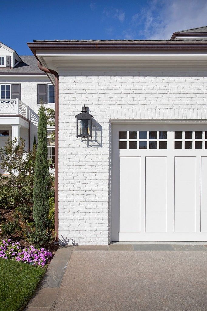 a white brick house with two garage doors